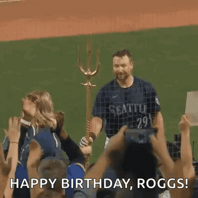 A Man In A Seattle Jersey Is Standing In Front Of A Crowd Holding A Trident And Saying Happy Birthday Roggs GIF