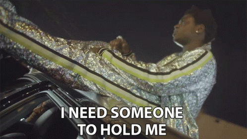 A Man In A Sequined Jacket Sits On The Roof Of A Car And Says I Need Someone To Hold Me GIF