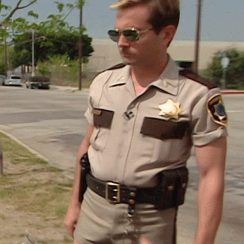 A Man In A Sheriff 'S Uniform Has A Star On His Badge GIF