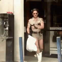 A Man In A Sheriff 'S Uniform Is Carrying A Bag GIF