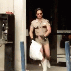 A Man In A Sheriff 'S Uniform Is Carrying A White Bag GIF