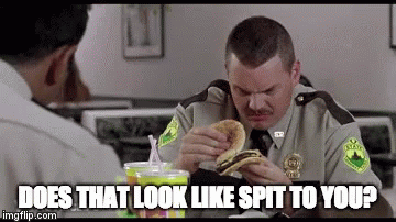 A Man In A Sheriff 'S Uniform Is Eating A Hamburger With The Caption Does That Look Like Spit To You .. GIF