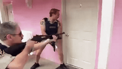 A Man In A Sheriff 'S Uniform Is Pointing A Gun At Another Man In A Room . GIF