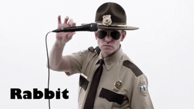 A Man In A Sheriff 'S Uniform Is Singing Into A Microphone With The Word Rabbit Written Below Him GIF