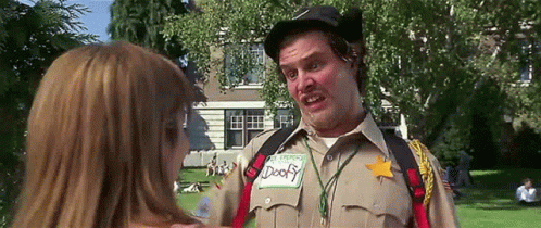A Man In A Sheriff 'S Uniform Is Talking To A Woman In Front Of A House . GIF