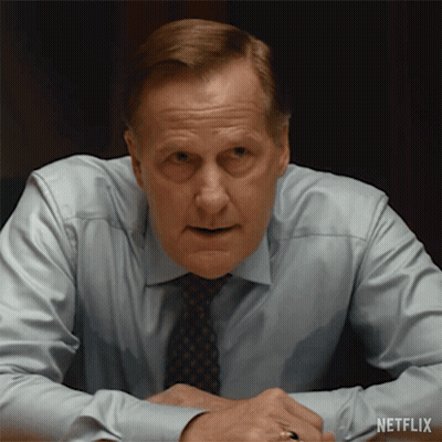 A Man In A Shirt And Tie Is Sitting At A Table With A Netflix Logo On The Bottom Right GIF
