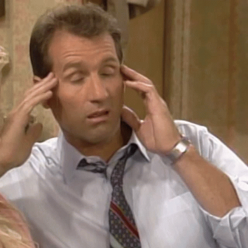 A Man In A Shirt And Tie Is Touching His Forehead GIF