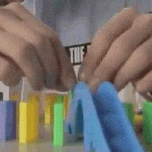 A Man In A Shirt That Says " The Out " Is Playing With Dominoes GIF