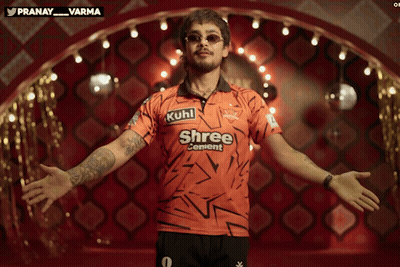 A Man In A Shree Cement Shirt Stands With His Arms Outstretched GIF