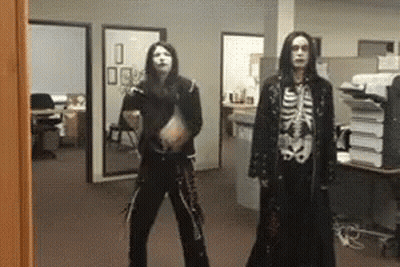 A Man In A Skeleton Costume Is Standing Next To Another Man In A Black Coat GIF