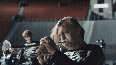 A Man In A Skeleton Shirt Plays A Trumpet In A Band GIF