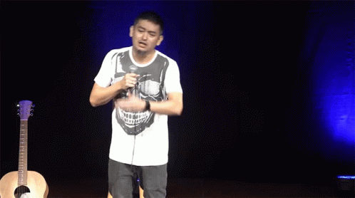 Man In Skull Shirt Singing In Front Of Microphone GIF