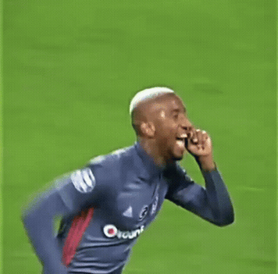 A Man In A Soccer Jersey Is Running On A Field And Giving The Middle Finger . GIF