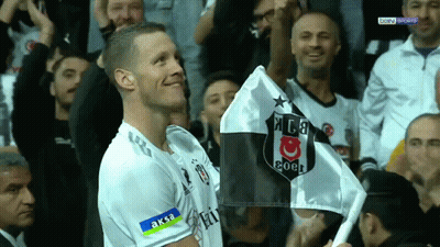 A Man In A Soccer Uniform Holds A Black And White Flag With The Letters Ksb On It GIF