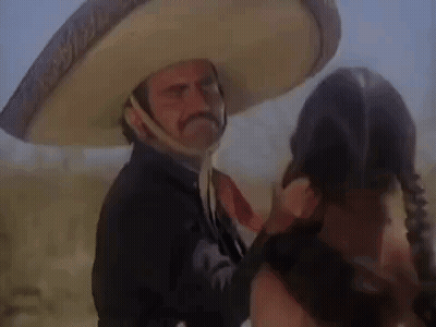 A Man In A Sombrero Is Talking To A Woman In A Field . GIF