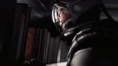 A Man In A Space Helmet Is Looking Out Of A Window . GIF