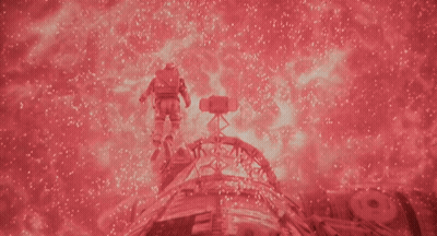 A Man In A Space Suit Is Surrounded By Red Sparkles GIF