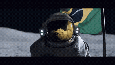 A Man In A Space Suit Stands In Front Of A Brazilian Flag On The Moon GIF