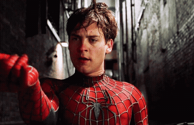 A Man In A Spider-Man Costume Is Pointing At Something GIF