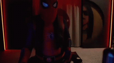 A Man In A Spider-Man Costume Is Sitting In Front Of A Computer In A Room . GIF