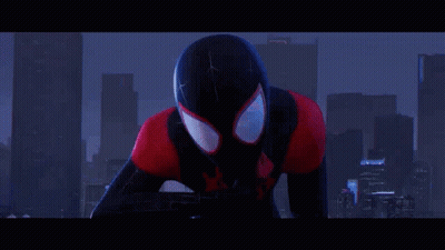 A Man In A Spider-Man Costume Is Standing In Front Of A City Skyline At Night . GIF