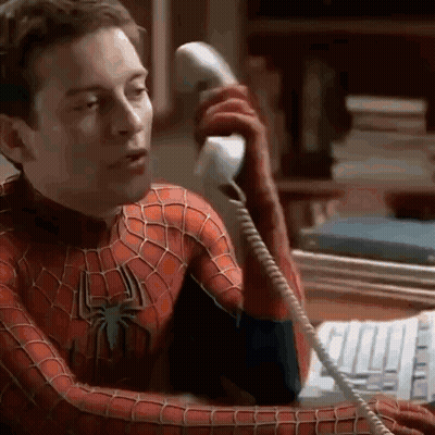 A Man In A Spider-Man Costume Is Talking On A Telephone . GIF