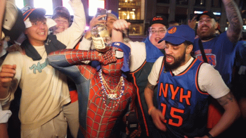 A Man In A Spiderman Costume Holds A Bottle Of Whiskey Surrounded By Nyk Fans GIF