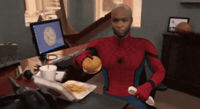 A Man In A Spiderman Costume Holds A Hamburger In His Hand GIF