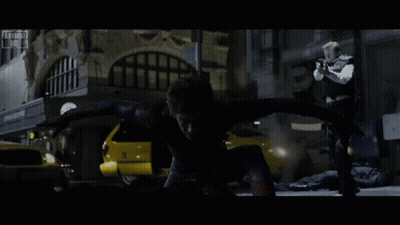 A Man In A Spiderman Costume Is Being Chased By A Man In A Black Vest GIF