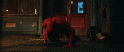 A Man In A Spiderman Costume Is Crawling On The Sidewalk GIF