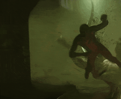 A Man In A Spiderman Costume Is Crawling Through A Dark Cave GIF