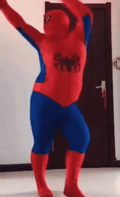 A Man In A Spiderman Costume Is Dancing In A Room . GIF
