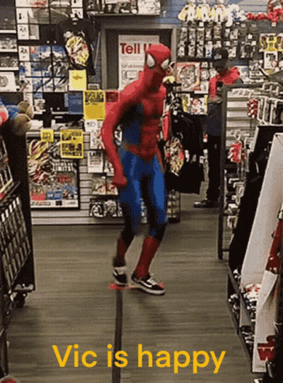 A Man In A Spiderman Costume Is Dancing In A Store With The Words Vic Is Happy Below Him GIF