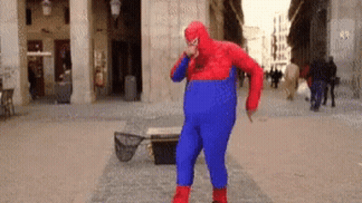 A Man In A Spiderman Costume Is Dancing On A Street GIF