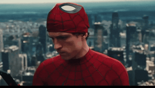 A Man In A Spiderman Costume Is Holding A Sword In Front Of A City Skyline GIF