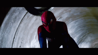 A Man In A Spiderman Costume Is Looking Down At Something GIF