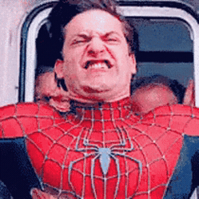A Man In A Spiderman Costume Is Making A Funny Face While Sitting In A Car . GIF