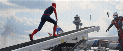 a man in a spiderman costume is running down a ramp next to an ant man