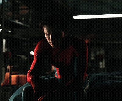 A Man In A Spiderman Costume Is Sitting Down GIF