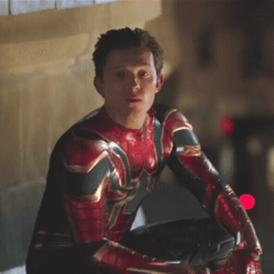 A Man In A Spiderman Costume Is Sitting On A Ledge Looking At Something . GIF