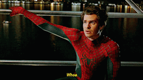 A Man In A Spiderman Costume Is Sitting On A Railing And Says Whoa GIF