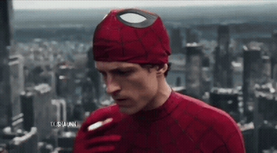 A Man In A Spiderman Costume Is Smoking A Cigarette In Front Of A City Skyline . GIF