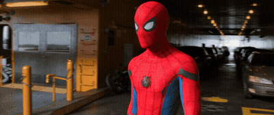 A Man In A Spiderman Costume Is Standing In A Parking Lot GIF