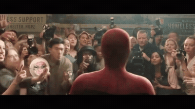 A Man In A Spiderman Costume Is Standing In Front Of A Crowd GIF