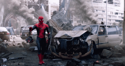 A Man In A Spiderman Costume Is Standing In Front Of A Destroyed City GIF