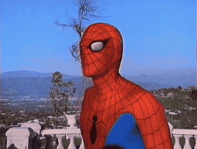 A Man In A Spiderman Costume Is Standing On A Balcony Overlooking A City GIF
