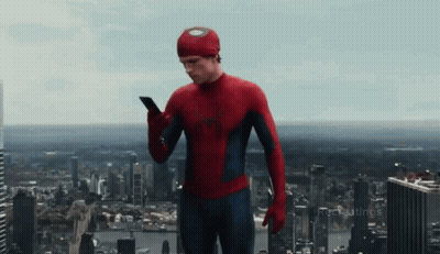 A Man In A Spiderman Costume Is Using A Cell Phone GIF