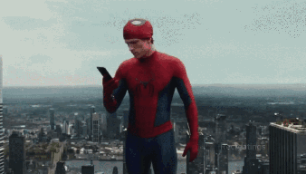 A Man In A Spiderman Costume Is Using A Cell Phone GIF