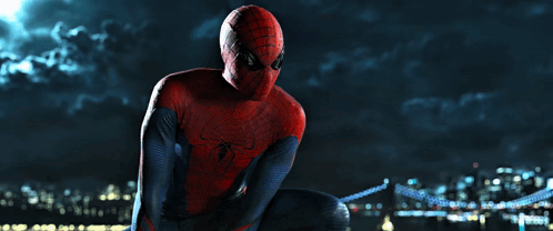 A Man In A Spiderman Costume Sits On A Bridge GIF