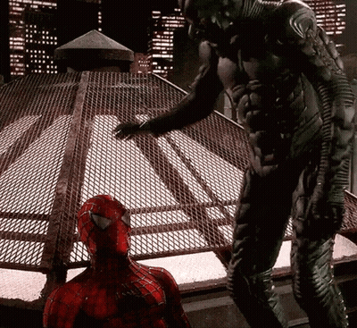 A Man In A Spiderman Costume Standing Next To Another Man In A Black Suit GIF